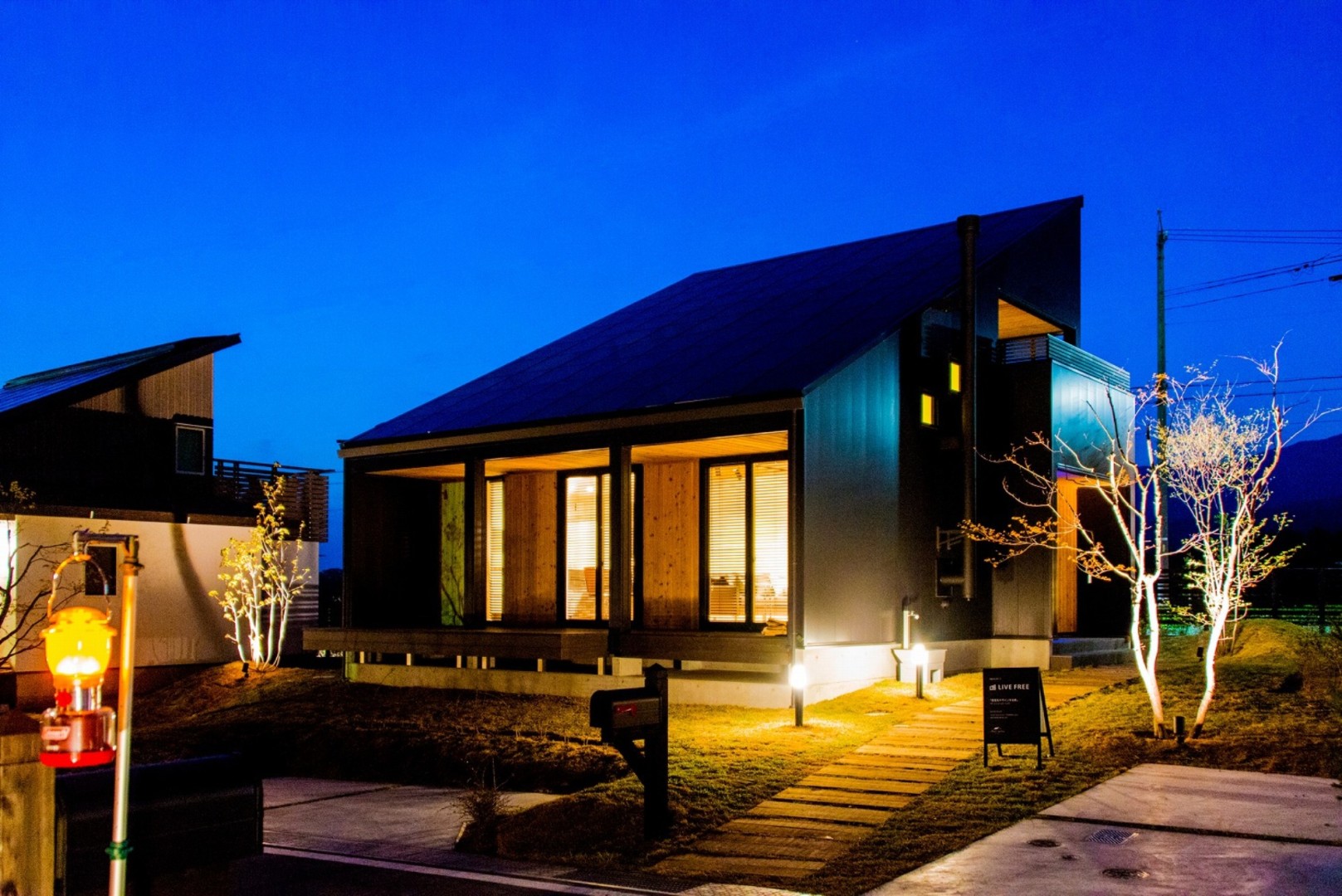 夜景外観写真。広々としたウッドデッキとシャープな外観が特徴。屋根にはソーラーパネル１０．５Kw搭載。電気代を気にせず暮らせる先進