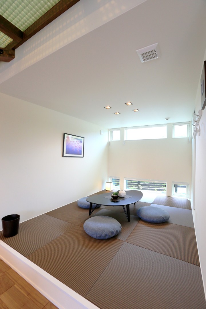 １F和室。小上がりを造作し、耐久性の高い和紙畳を使用しています。高窓と地窓により明るい空間にしながら、外部の目線を遮ります。