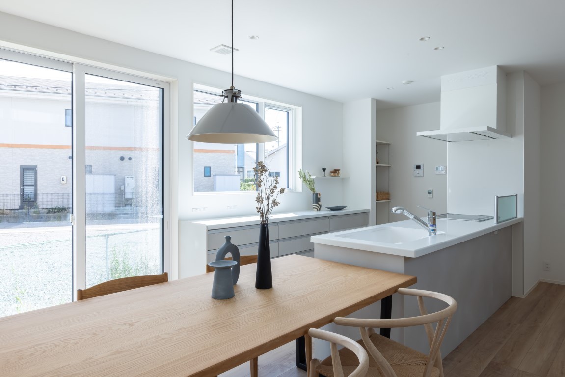 壁一面のロングカウンター収納は、お気に入りの家電を並べてギャラリーのように。奥にはパントリーも完備。